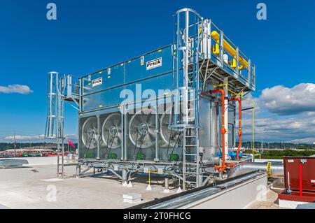 Un grand condenseur de réfrigération industriel commercial avec 4 ventilateurs apparaissant sur le toit d'une installation d'entreposage frigorifique. Banque D'Images