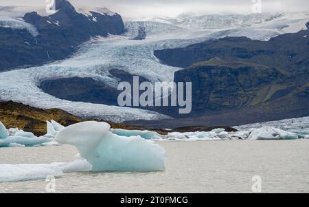 Un glacier coulant au large de la plus haute montagne d'Islande, le volcan Öræfajökull, avec la lagune glaciaire de Fjallsárlón Banque D'Images