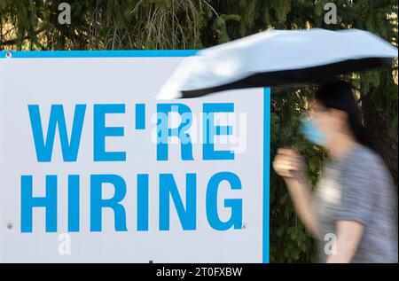 Toronto, Canada. 6 octobre 2023. Une femme passe devant une affiche d'emploi près d'une rue de Toronto, Canada, le 6 octobre 2023. Le nombre d'emplois au Canada a augmenté de 64 000 en septembre, après une hausse de 40 000 en août, a déclaré Statistique Canada vendredi. Crédit : Zou Zheng/Xinhua/Alamy Live News Banque D'Images