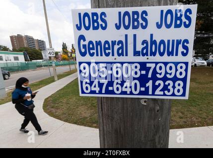 Toronto, Canada. 6 octobre 2023. Une femme passe devant une affiche d'emploi sur un poteau de rue à Toronto, Canada, le 6 octobre 2023. Le nombre d'emplois au Canada a augmenté de 64 000 en septembre, après une hausse de 40 000 en août, a déclaré Statistique Canada vendredi. Crédit : Zou Zheng/Xinhua/Alamy Live News Banque D'Images