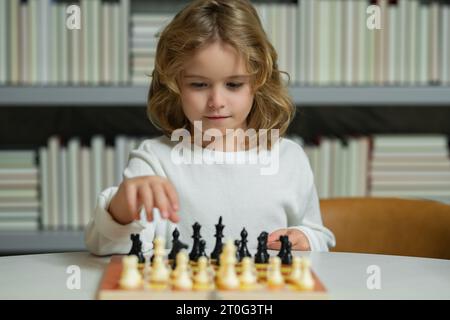 École d'échecs. Échecs de jeu d'enfant concentré. Enfant jouant à un jeu de société en classe Banque D'Images