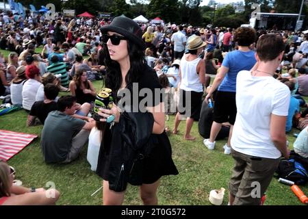 Un goth d'été stylisé en femme noire se déplace à travers la foule des gens au Newtown Festival 2012 - Camperdown Park, Sydney Banque D'Images