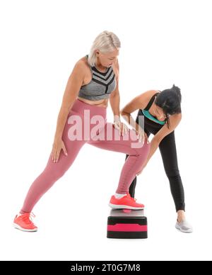 Formation de femme mature avec stepper et thérapeute de réadaptation sur fond blanc Banque D'Images
