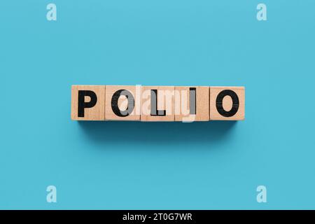 Mot POLIO fait de cubes en bois sur fond bleu Banque D'Images