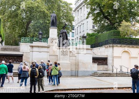 Londres The Mall, les groupes de visites touristiques visitent les statues de la reine Elizabeth la reine mère et du roi George V1 sur le centre commercial à Londres, Angleterre, Royaume-Uni Banque D'Images