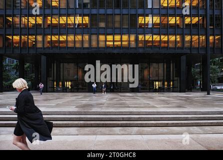 Une femme se promène dans l'emblématique bâtiment Seagram, de l'architecte Ludwig Mies van der Rohe à Midtown Manhattan, New York. Banque D'Images