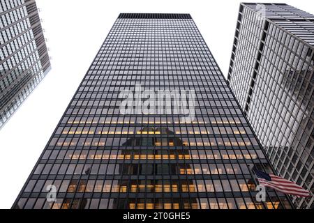 Un drapeau américain flotte devant l'emblématique bâtiment Seagram, de l'architecte Ludwig Mies van der Rohe à Midtown Manhattan, New York. Banque D'Images