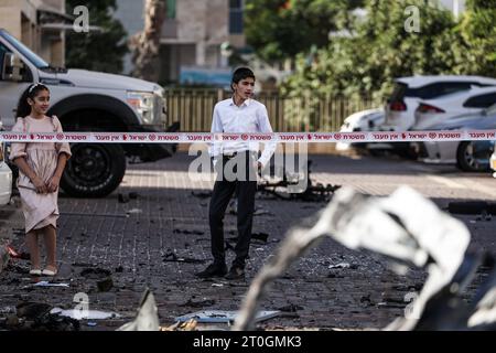 Ashkelon, Israël. 07 octobre 2023. Les résidents regardent les débris de véhicules détruits à la suite d’une attaque à la roquette depuis Gaza. Des militants palestiniens à Gaza ont tiré de manière inattendue des dizaines de roquettes sur des cibles israéliennes tôt samedi, a déclaré l’armée israélienne. Crédit : Ilia Yefimovich/dpa/Alamy Live News Banque D'Images