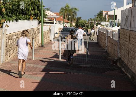 Ashkelon, Israël. 07 octobre 2023. Les résidents tentent de se mettre à couvert lors d’une attaque à la roquette depuis Gaza. Des militants palestiniens à Gaza ont tiré de manière inattendue des dizaines de roquettes sur des cibles israéliennes tôt samedi, a déclaré l’armée israélienne. Crédit : Ilia Yefimovich/dpa/Alamy Live News Banque D'Images