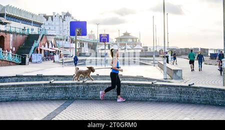 Brighton Royaume-Uni 7 octobre 2023 - les coureurs et les marcheurs profitent d'une matinée chaude et ensoleillée sur le front de mer de Brighton car les températures devraient être exceptionnellement élevées pour la période de l'année dans certaines parties de la Grande-Bretagne : Credit Simon Dack / Alamy Live News Banque D'Images