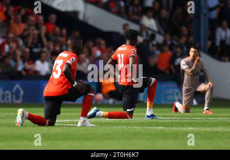 Elijah Adebayo de Luton Town (au centre) et les joueurs se mettent à genoux avant le coup d'envoi du match de Premier League à Kenilworth Road, Luton. Date de la photo : Samedi 7 octobre 2023. Banque D'Images