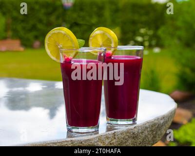 Jus fraîchement pressé de betterave avec pomme et citron dans un verre à jus Banque D'Images