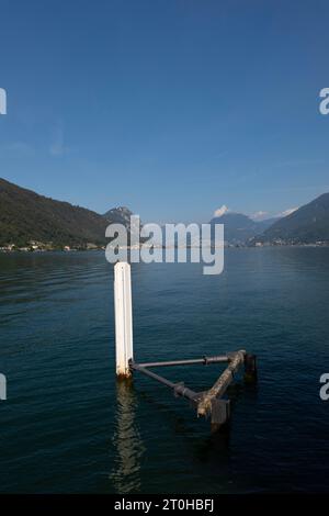 Jetée à Brusino Arsizio sur le front de mer dans une journée d'été ensoleillée sur le lac de Lugano et montagne à Brusino Arsizio, Tessin, Suisse Banque D'Images
