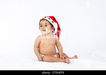 Un petit garçon avec un chapeau de noël rouge sur fond blanc, espace de copie Banque D'Images