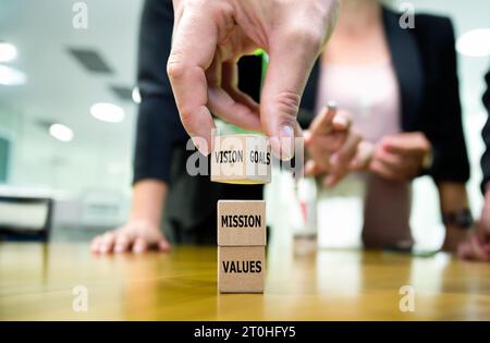A stack of wooden cubes sow the words values, mission, vision and goals. Stock Photo