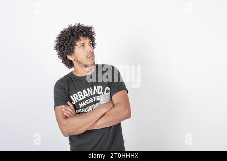 homme noir réfléchi avec les bras pliés regardant sur le côté, fond blanc horizontal Banque D'Images