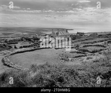 La cabane Ty Mawr East tourne sur les pentes inférieures de Holyhead Mountain, Anglesey : en regardant au sud-ouest une 'propriété' de l'âge du fer de 2 maisons rondes dans une cour de ferme Banque D'Images