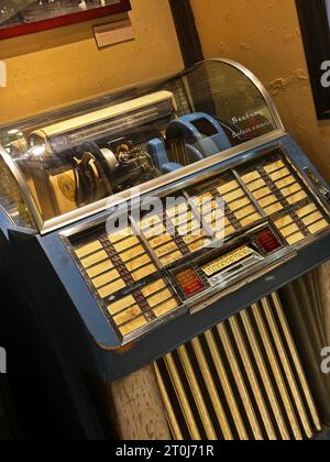 Juke-box vintage avec détails chromés et panneau de sélection, présentant la technologie musicale classique et un design de divertissement rétro nostalgique dans un set d'affichage Banque D'Images
