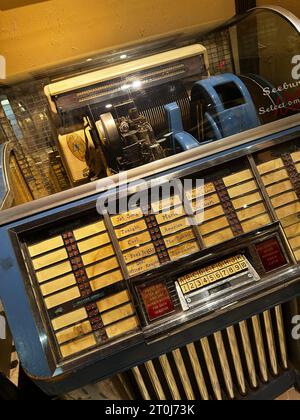 Juke-box vintage avec détails chromés et panneau de sélection, présentant la technologie musicale classique et un design de divertissement rétro nostalgique dans un set d'affichage Banque D'Images