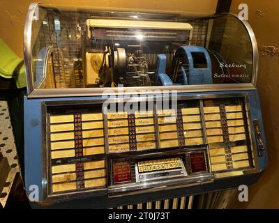 Juke-box vintage avec détails chromés et panneau de sélection, présentant la technologie musicale classique et un design de divertissement rétro nostalgique dans un set d'affichage Banque D'Images