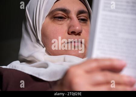 Femme musulmane portant le livre de lecture du hijab Banque D'Images