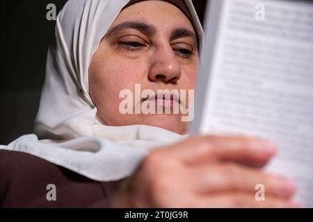 Femme musulmane portant le livre de lecture du hijab Banque D'Images