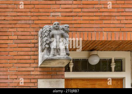 une statue d'ange sur le côté d'un bâtiment en briques avec une porte et une fenêtre en bois sur la photo est prise d'en haut Banque D'Images