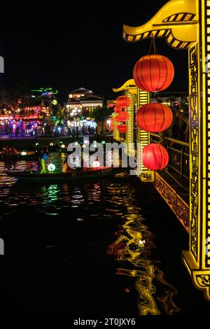 Hoi an, Vietnam. Pont piétonnier et bateaux touristiques sur la rivière Thu bon la nuit. Banque D'Images