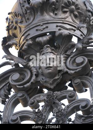 Couronne en fer forgé, croix et visage sur une porte d'entrée du jardin de la cour de la résidence Würzburg Banque D'Images