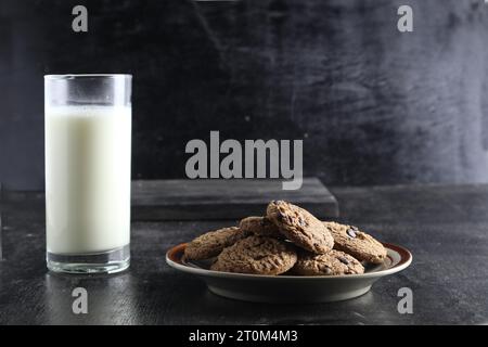 biscuits et lait sur fond noir Banque D'Images