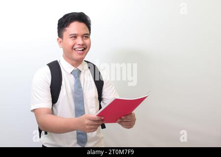 Lycéen indonésien portant un uniforme de chemise blanche avec cravate grise soumettant son rapport de journal à quelqu'un pour approbation. Image isolée Banque D'Images