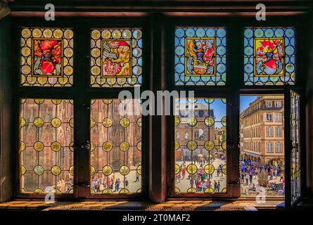 Strasbourg, France - 31 mai 2023 : façade gothique ornée de la cathédrale notre-Dame vue à travers les vitraux du restaurant Maison Kammerzell Banque D'Images