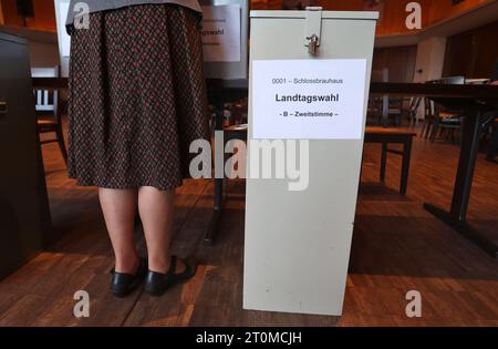 Schwangau, Allemagne. 08 octobre 2023. Un travailleur électoral se tient près d'une urne dans un bureau de vote. En Bavière, l'élection du 19e Parlement bavarois a lieu dimanche. Crédit : Karl-Josef Hildenbrand/dpa/Alamy Live News Banque D'Images