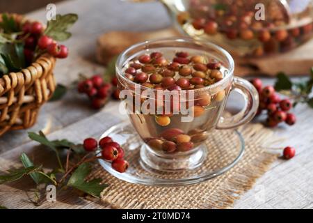 Tisane à base de baies fraîches d'aubépine en automne dans une tasse en verre Banque D'Images