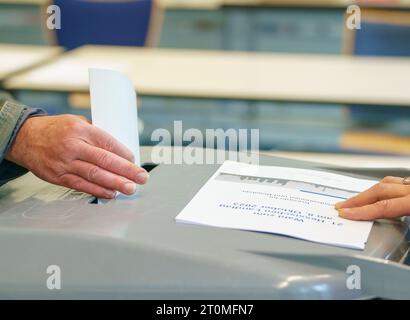 Offenbach, Allemagne. 08 octobre 2023. Un homme jette son bulletin de vote dans l'urne dans la salle de vote du centre d'éducation des adultes de Sonnemannstrasse. En Hesse, l'élection du 21e Parlement de l'État de Hesse a lieu dimanche. Crédit : Andreas Arnold/dpa/Alamy Live News Banque D'Images