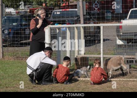 Une famille juive orthodoxe célèbre Soukkos en visitant un zoo pour enfants et un endroit amusant pour les enfants. A Monsey, New York. Banque D'Images