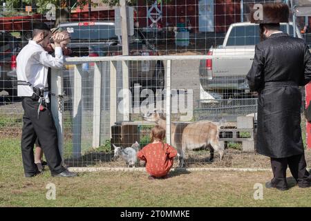 Une famille juive orthodoxe célèbre Soukkos en visitant un zoo pour enfants et un endroit amusant pour les enfants. A Monsey, New York. Banque D'Images