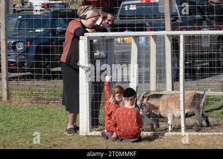 Une famille juive orthodoxe célèbre Sukkos en visitant une ferme, un zoo pour enfants et un endroit amusant pour les enfants. À Monsey, New York. Banque D'Images