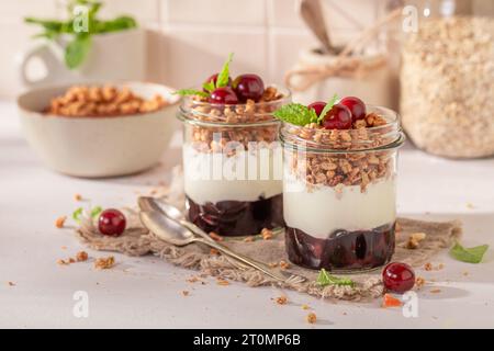 Granola aux cerises fraîches et saines à base de fruits et de yaourt. Petit-déjeuner d'été avec cerises et yaourt. Banque D'Images
