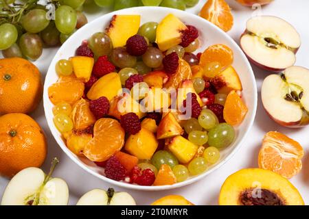Salade de fruits avec fruits tranchés, raisins mélangés, framboises, nectarines, mandarines et pommes Banque D'Images