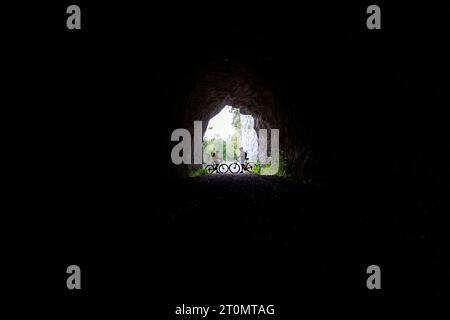 Mère et fils, touristes sur un voyage à vélo avec vtt dans la campagne autour de Pivka, à l'entrée de l'ancien tunnel militaire italien, slovénie Banque D'Images