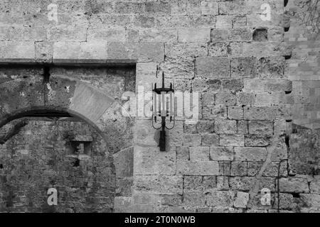 Ancienne lampe murale de style médiéval vintage sur les côtés de l'entrée de la porte de la vieille ville d'Amboise Rhodes en noir et blanc Banque D'Images
