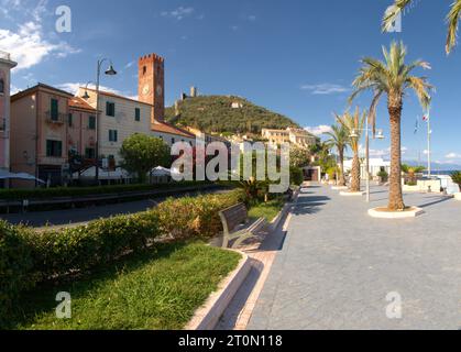 Front de mer à Noli montrant château, palmiers et Torre del Comune, Savone, Ligurie Banque D'Images