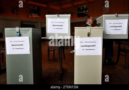 Schwangau, Allemagne. 08 octobre 2023. Un travailleur électoral est assis derrière des urnes dans un bureau de vote. En Bavière, l'élection du 19e Parlement bavarois a lieu dimanche. Crédit : Karl-Josef Hildenbrand/dpa/Alamy Live News Banque D'Images