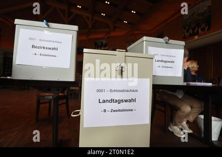 Schwangau, Allemagne. 08 octobre 2023. Les travailleurs électoraux sont assis derrière les urnes dans un bureau de vote. En Bavière, l'élection du 19e Parlement bavarois a lieu dimanche. Crédit : Karl-Josef Hildenbrand/dpa/Alamy Live News Banque D'Images