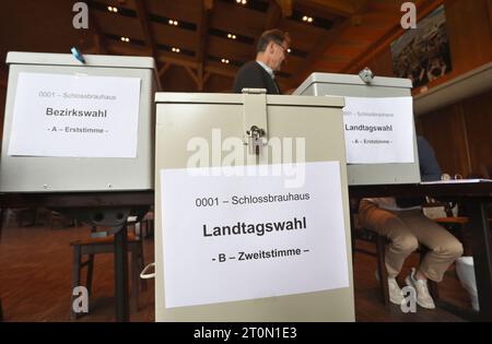 Schwangau, Allemagne. 08 octobre 2023. Les travailleurs électoraux sont assis derrière les urnes dans un bureau de vote. En Bavière, l'élection du 19e Parlement bavarois a lieu dimanche. Crédit : Karl-Josef Hildenbrand/dpa/Alamy Live News Banque D'Images