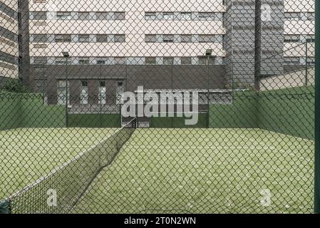 Court de paddle-tennis fermé avec clôtures métalliques, ampoules Banque D'Images