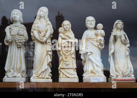 Petites statues ou figurines de saints dans une vitrine souvenir à côté de l'abbaye de Vézelay en France Banque D'Images