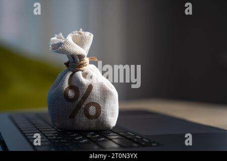 Sac avec symbole de pourcentage sur le clavier d'ordinateur portable. Crédits et prêts. Placements et dépôts. Dividendes, bénéfices des dépôts. Trading sur le stock exchang Banque D'Images