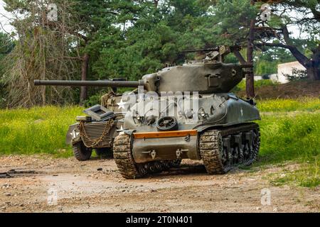 Un casque d'infanterie américain M1 de la Seconde Guerre mondiale repose sur le capot d'un véhicule militaire Banque D'Images